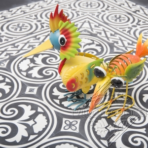 Bright metal birds on a black and white Cuban cement tile floor